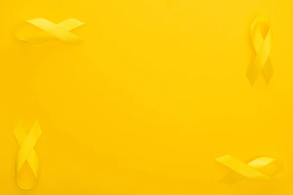Плоский лежал с желтыми лентами на красочном фоне, международная концепция детского дня рака — стоковое фото