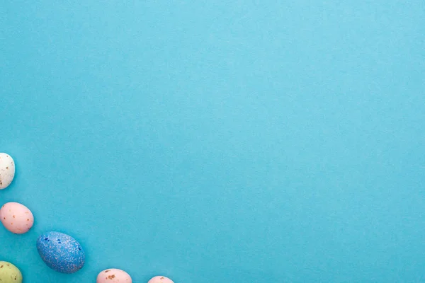 Top view of colorful chicken and quail eggs on blue background — Stock Photo