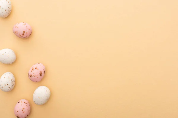 Top view of colorful quail eggs on beige background — Stock Photo