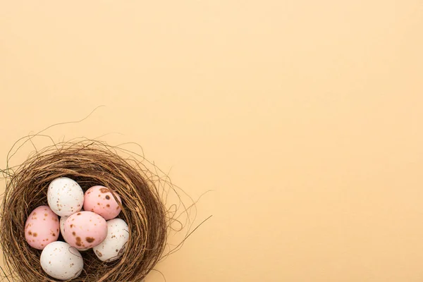 Vista dall'alto di uova di quaglia rosa e bianche su sfondo beige — Foto stock