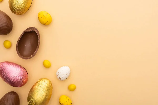 Top view of delicious chocolate and quail eggs with sweets on beige background — Stock Photo