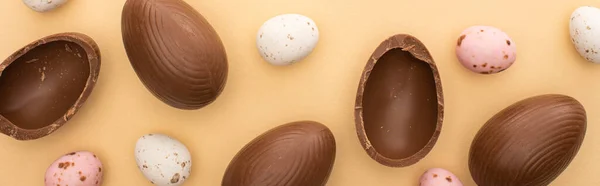 Panoramic shot of quail and chocolate eggs on beige background — Stock Photo