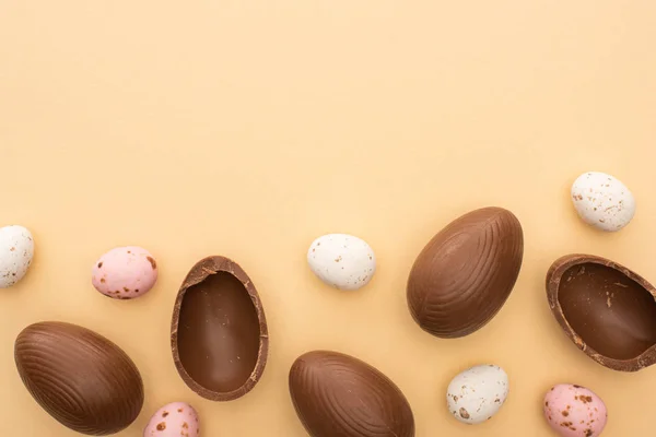 Vista dall'alto di uova di quaglia e cioccolato su sfondo beige — Foto stock