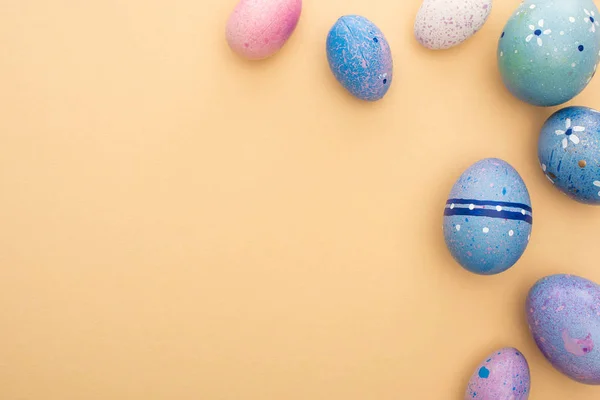 Vista superior de los huevos de Pascua sobre fondo beige - foto de stock