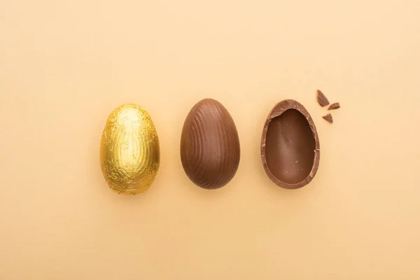 Vue du dessus des œufs de Pâques en chocolat sur fond beige — Photo de stock