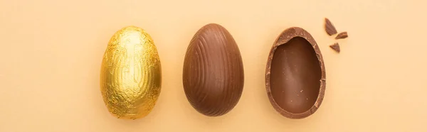 Vista superior de ovos de Páscoa de chocolate no fundo bege, tiro panorâmico — Fotografia de Stock