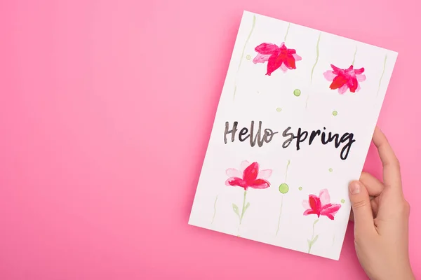 Ausgeschnittene Ansicht einer Frau mit Karte mit Hallo-Frühling-Schriftzug auf rosa — Stockfoto