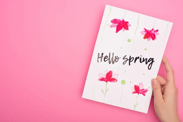 Cropped view of woman holding card with hello spring lettering on pink — Stock Photo