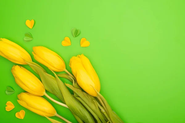 Vue du dessus des tulipes et des cœurs décoratifs colorés sur le vert, concept printemps — Photo de stock