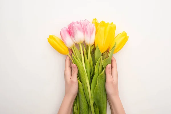 Vista recortada de la mujer sosteniendo ramo de tulipanes sobre fondo blanco, concepto de primavera - foto de stock