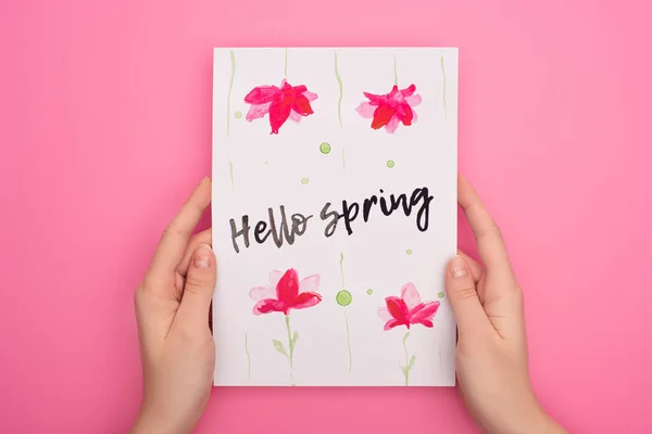 Vista recortada de la tarjeta de mujer con letras de primavera hola sobre fondo rosa - foto de stock