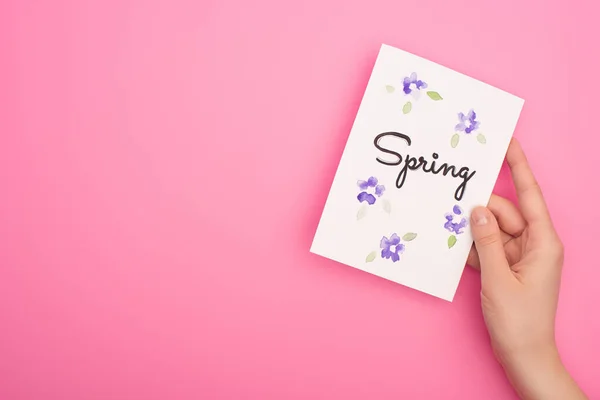 Partial view of woman holding card with spring lettering on pink background — Stock Photo