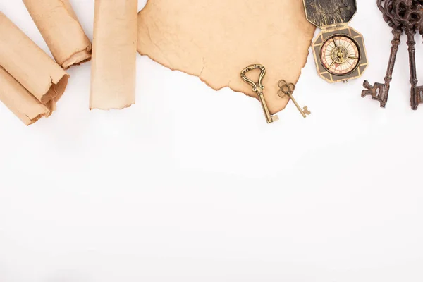 Top view of vintage keys and compass on aged paper isolated on white — Stock Photo