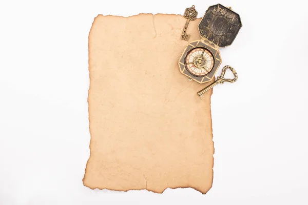 Vue de dessus des clés vintage et boussole sur papier vieilli isolé sur blanc — Photo de stock