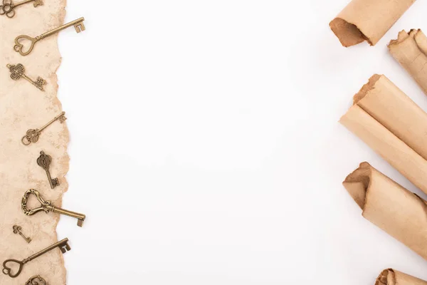 Top view of vintage keys on aged paper isolated on white — Stock Photo