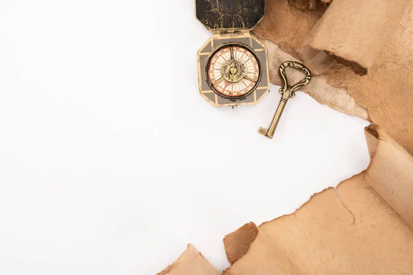 Vue de dessus de clé vintage, boussole et papier vieilli isolé sur blanc — Photo de stock