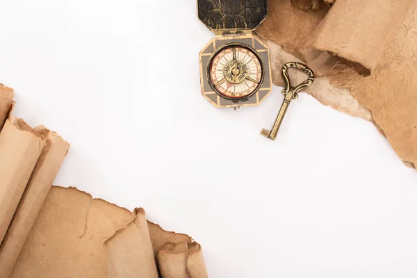 Vue de dessus de clé vintage, boussole et papier vieilli isolé sur blanc — Photo de stock