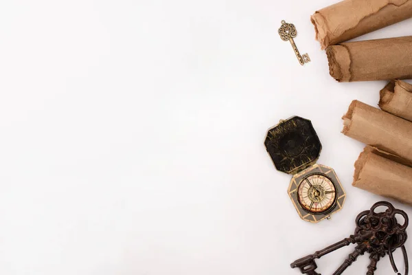 Vista superior de brújula vintage, llaves y papel pergamino envejecido aislado en blanco - foto de stock