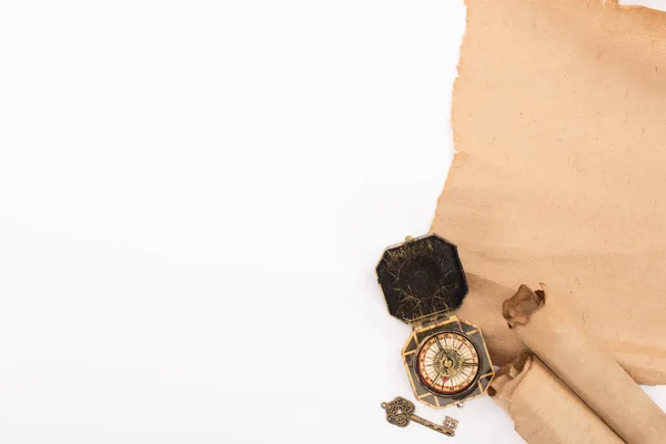 Draufsicht auf Vintage-Kompass, Schlüssel und gealtertes Pergamentpapier isoliert auf Weiß — Stockfoto