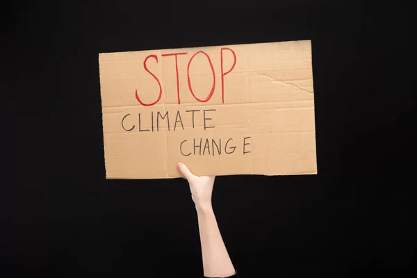 Partial view of woman holding placard with stop climate change lettering isolated on black, global warming concept — Stock Photo