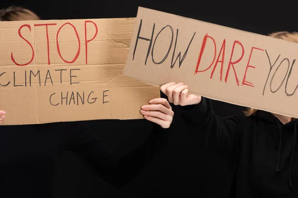 Ausgeschnittene Ansicht von Blondinen mit Plakaten mit Stopp des Klimawandels und wie wagen Sie es, isoliert auf schwarzem, globalem Erwärmungskonzept zu schreiben — Stockfoto