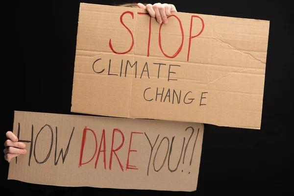 Ausgeschnittene Ansicht einer Frau mit Plakaten mit Stopp des Klimawandels und wie wagen Sie es, isoliert auf schwarzem, globalem Erwärmungskonzept zu schreiben — Stockfoto