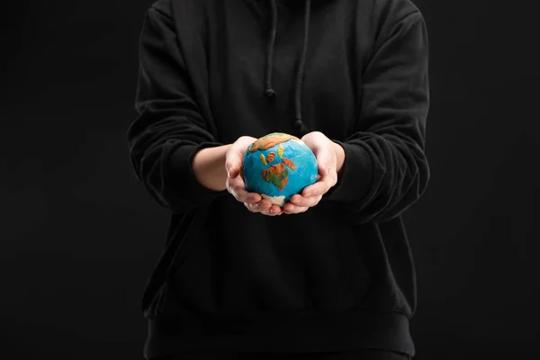 Vista parziale della donna con globo di plastilina isolato sul nero, concetto di riscaldamento globale — Foto stock