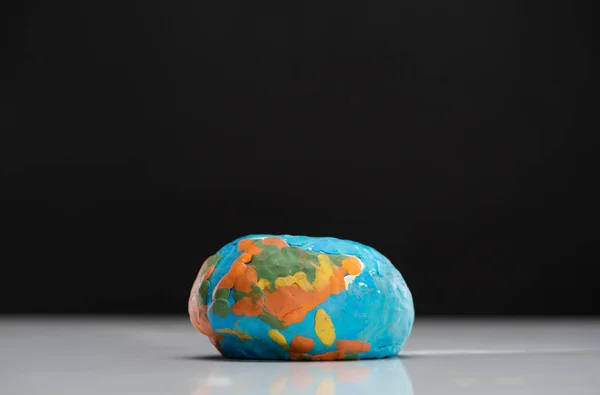 Плоский пластилиновый глобус, изолированный на черной концепции глобального потепления — стоковое фото