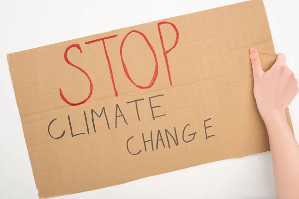 Vista recortada de la mujer sosteniendo pancarta con letras de stop climate change sobre fondo blanco, concepto de calentamiento global - foto de stock