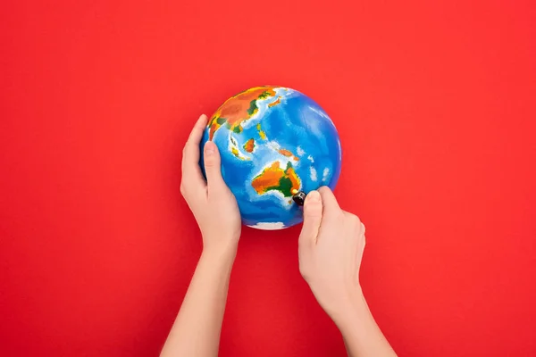 Cropped view of woman setting to fire globe on red, global warming concept — Stock Photo