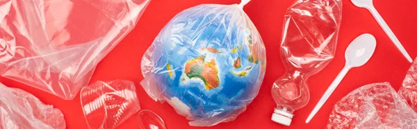 Panoramic view of globe in plastic bag with garbage around on red, global warming concept — Stock Photo