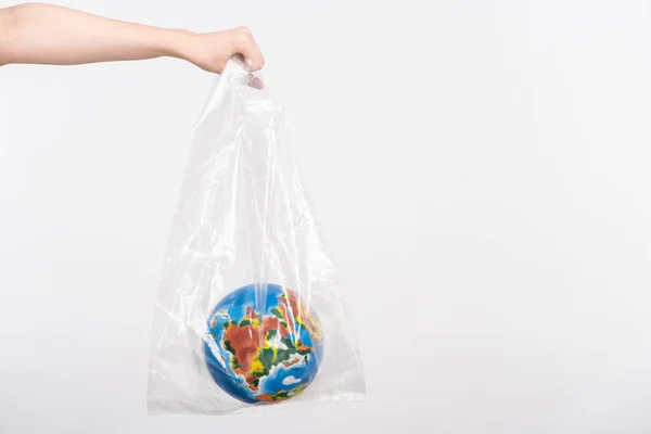 Cropped view of woman with outstretched hand holding globe in plastic bag isolated on white, global warming concept — Stock Photo