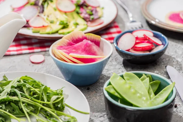 Селективный фокус свежих ингредиентов салата редис на серой бетонной поверхности — стоковое фото