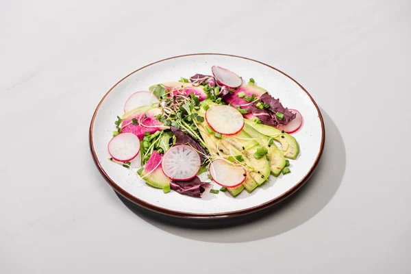 Insalata di ravanello fresco con verdure e avocado sulla superficie grigia — Foto stock