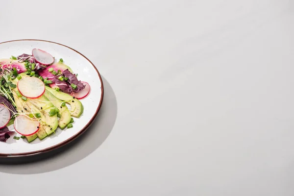 Insalata di ravanello fresco con verdure e avocado sulla superficie grigia — Foto stock