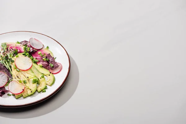 Salada de rabanete fresco com verduras e abacate na superfície cinza — Fotografia de Stock