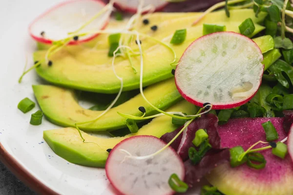 Vista de perto de salada de rabanete fresco com verdes e abacate — Fotografia de Stock