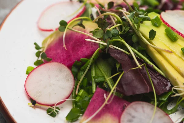 Close up view of fresh radish salad with greens and avocado — Stock Photo