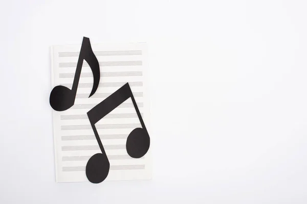 Top view of paper cut notes on music book on white background — Stock Photo