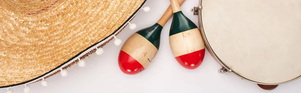 Vista superior de maracas de madera con pandereta y sombrero sobre fondo blanco, plano panorámico - foto de stock