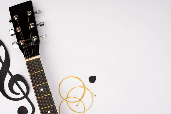 Vue du dessus de la guitare acoustique et du papier coupés note de musique sur fond blanc — Photo de stock