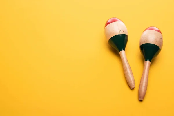 Vista dall'alto di maracas di legno su sfondo giallo — Foto stock