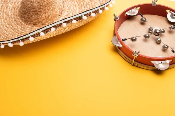 Tambourine and mexican sombrero on yellow background — Stock Photo