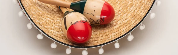 Close up view of maracas on sombrero on white background, panoramic shot — Stock Photo