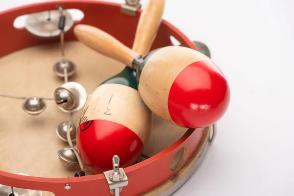 Vue rapprochée des maracas en bois sur tambourin sur fond blanc — Photo de stock