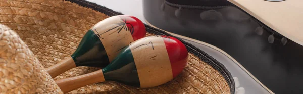 Vista de perto de maracas de madeira no sombrero e guitarra acústica no fundo branco, tiro panorâmico — Fotografia de Stock