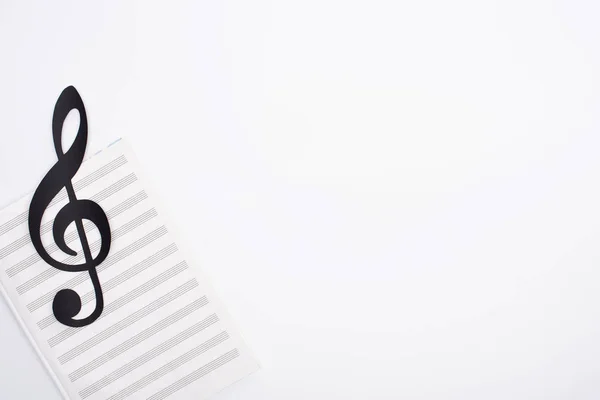 Draufsicht auf schwarze Notiz mit Notenbuch auf weißem Hintergrund — Stockfoto