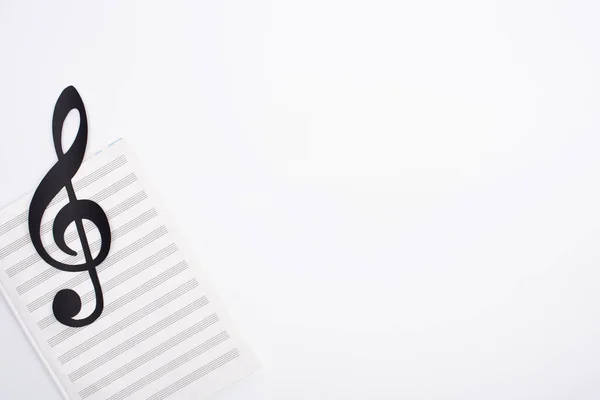 Top view of black paper cut note with music book on white background — Stock Photo