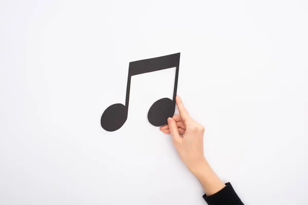 Vista cortada de mulher segurando papel cortar nota música preta no fundo branco — Fotografia de Stock