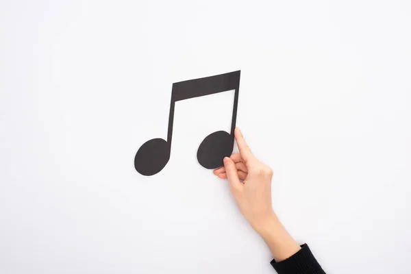 Cropped view of woman holding paper cut black music note on white background — Stock Photo